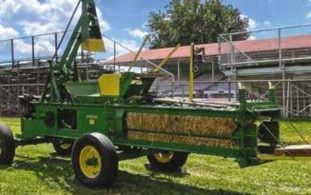 Cover photo: green John Deere baler in front of the grandstand