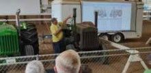 Seminar speaker presenting next to a tractor