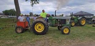 John Deere tractor with a small red cart