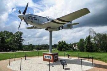 Vintage fighter plane mounted on a pedestal outside MAPS Air Museum